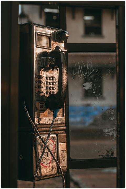 A vintage telephone booth with a rusty exterior on
