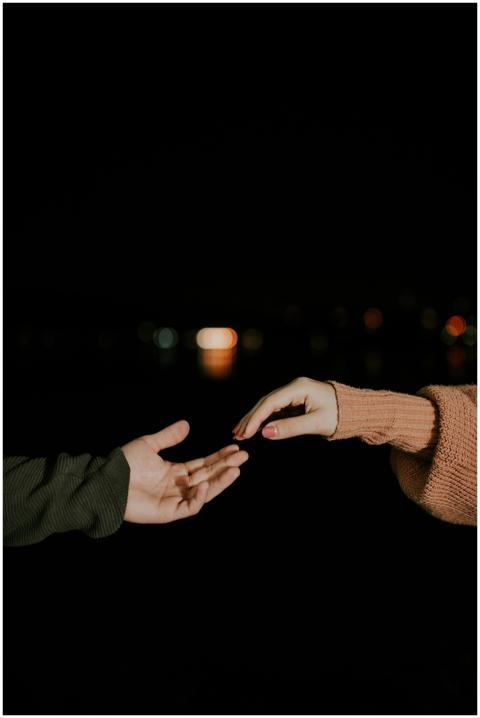 A poetic night scene of two hands reaching towards
