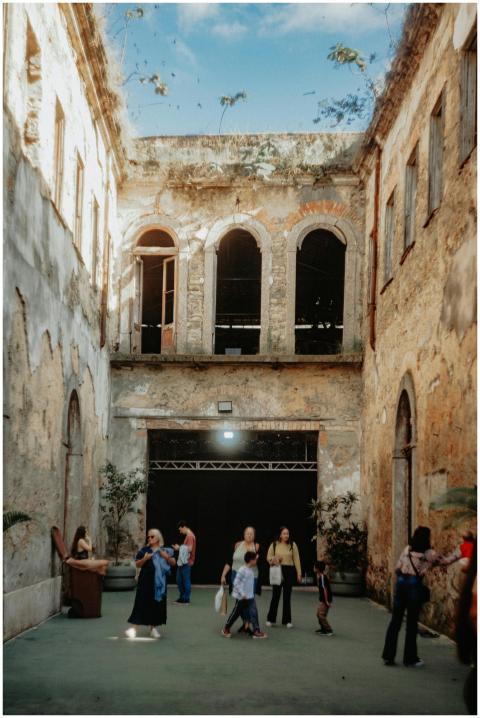 People exploring a historic courtyard with weather