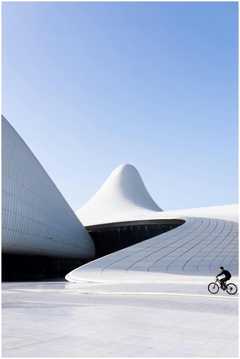 Bicyclist rides past the futuristic Heydar Aliyev