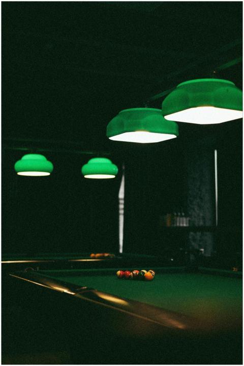Dimly lit billiards room with a pool table and gre