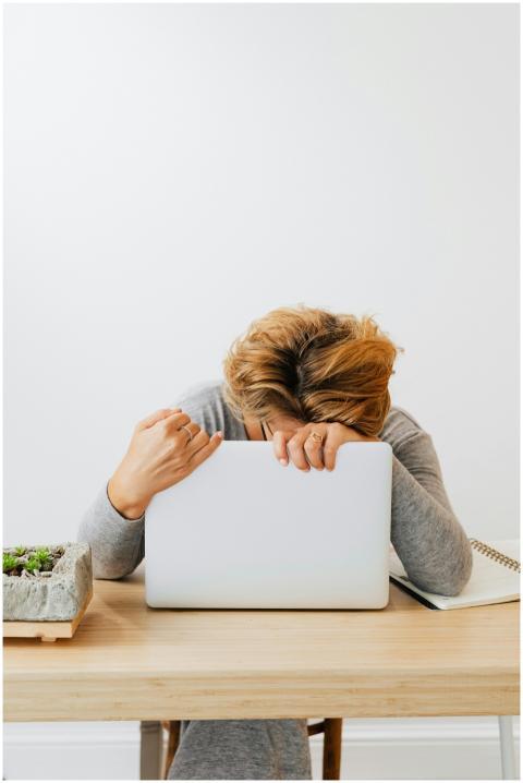 Woman showing fatigue resting head on laptop, work
