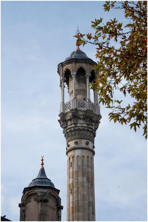 Tall minaret with intricate design against sky, su