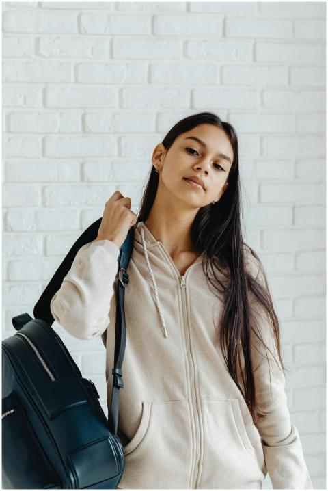 Confident teenager with a backpack and hoodie pose