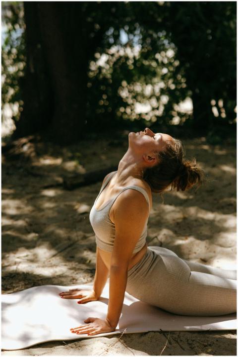 A woman performs yoga on a sunny day in a serene o