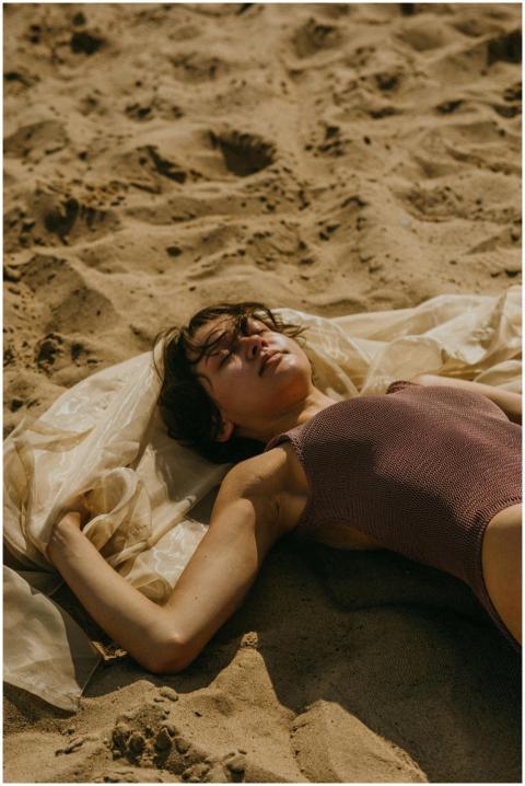 Woman relaxing and sunbathing on a sandy beach in