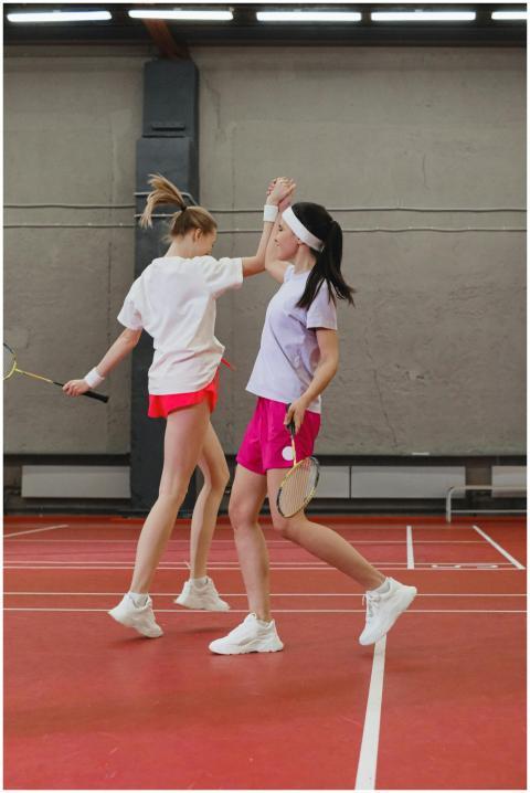Two young women badminton players celebrate with a