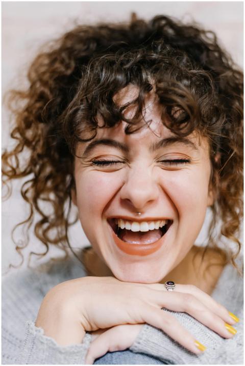 Close-up portrait of a smiling woman with curly ha