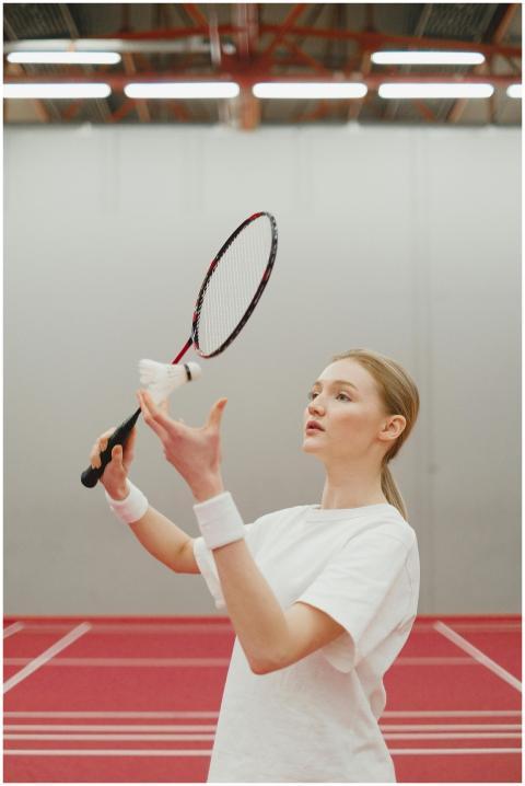 Young woman in white shirt concentrating on badmin