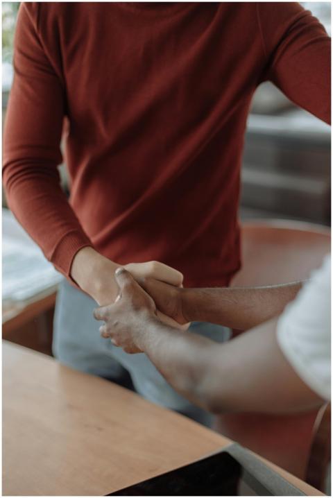 Close-up of two businessmen shaking hands, symboli