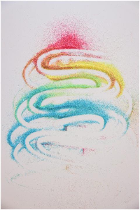 Colorful abstract art with rainbow sand on a white