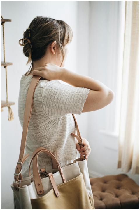 A woman holding a handcrafted canvas and leather t