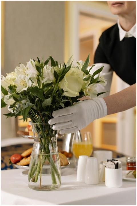 Woman arranging flowers in a hotel room with break
