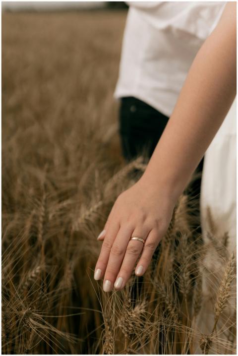 A woman's hand with a ring softly touches a golden