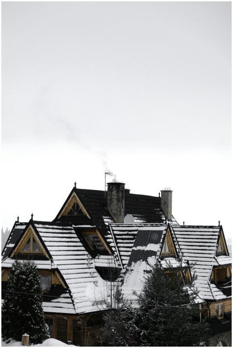 A cozy wooden house in winter surrounded by snow i