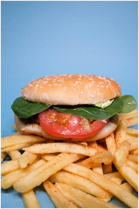 Burger with tomatoes slices and green leaves with