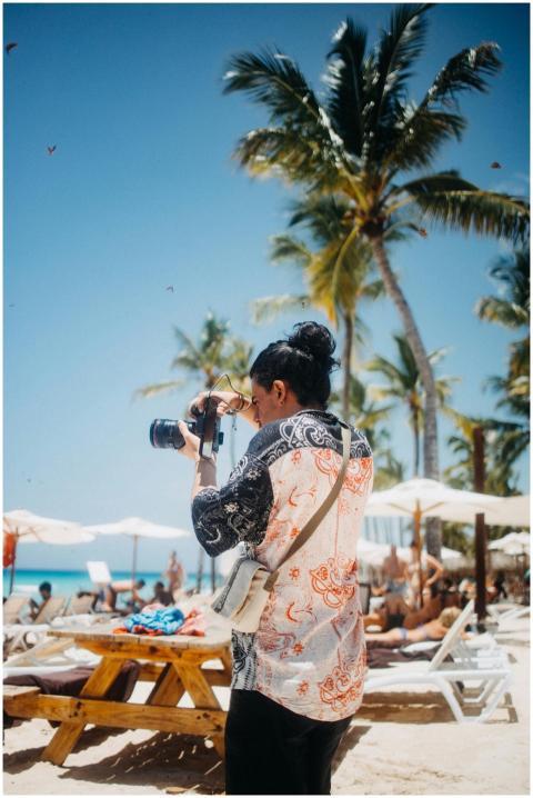 A photographer takes pictures on a sunny beach wit
