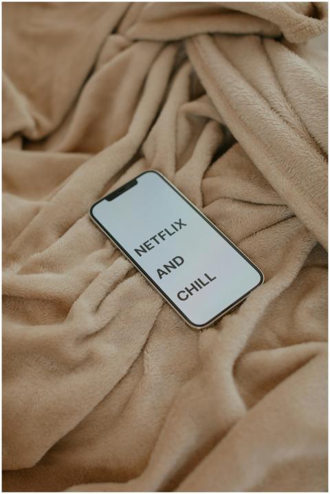 Smartphone displaying 'Netflix and Chill' on a bei