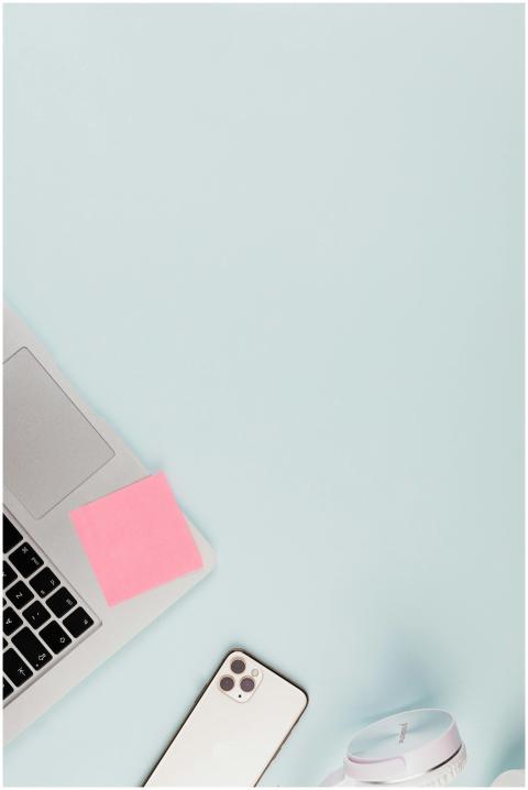 Top-down view of a tidy desk with a laptop, smartp