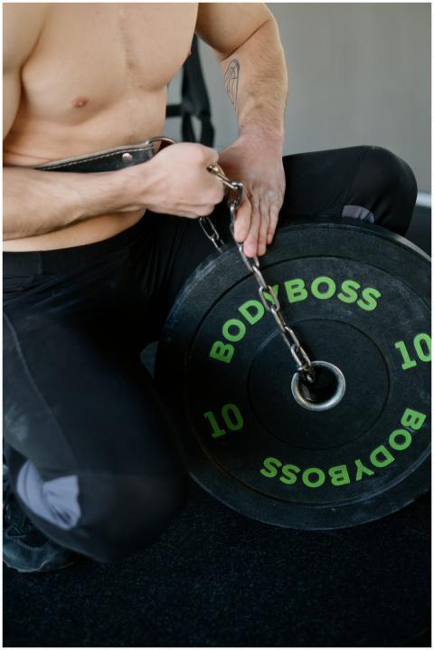 Athletic man setting up weights with chains for st