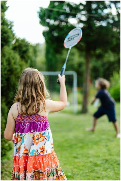 Two children enjoy a game of badminton outdoors in