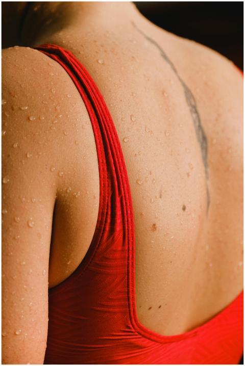 Close-up of a woman's back in a red swimsuit with