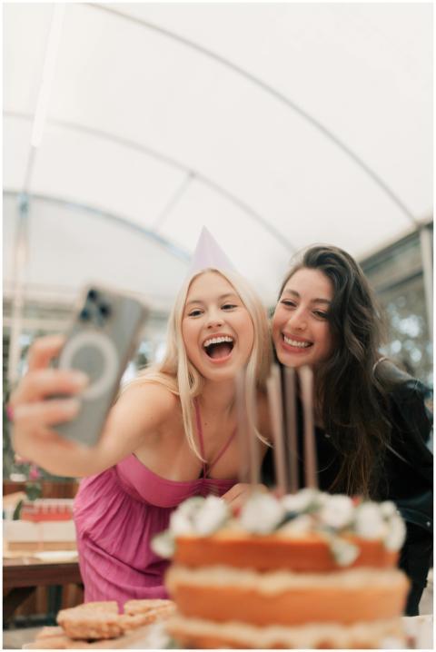 Two friends celebrating a birthday with a cake, ca