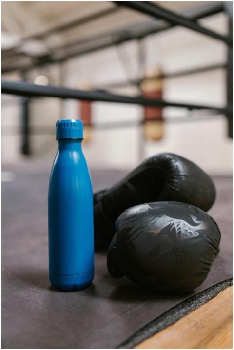 Close-up of a blue bottle and black boxing gloves