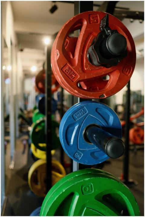 Stack of colorful weight plates in a modern gym, p