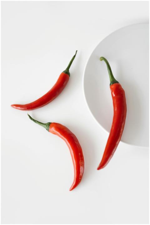 Close-up of vibrant red chili peppers on a minimal