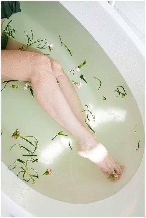 A serene top view of legs in a bathtub with floati