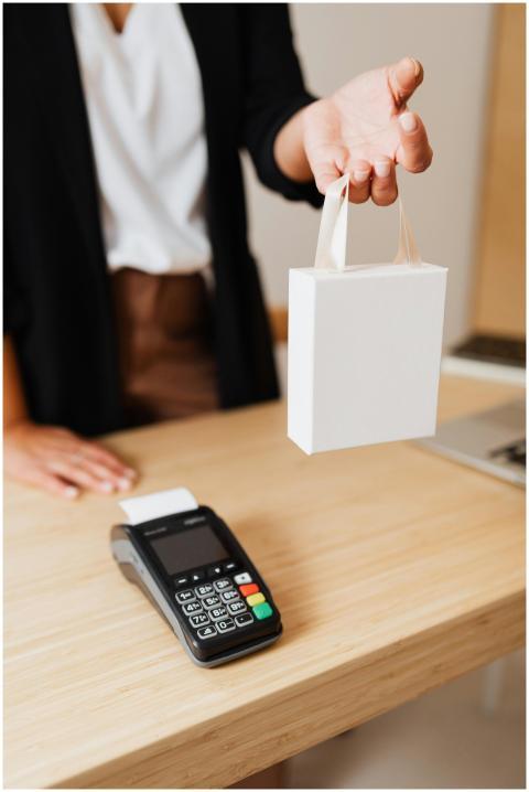 Close-up of shopper's hand holding a bag next to a