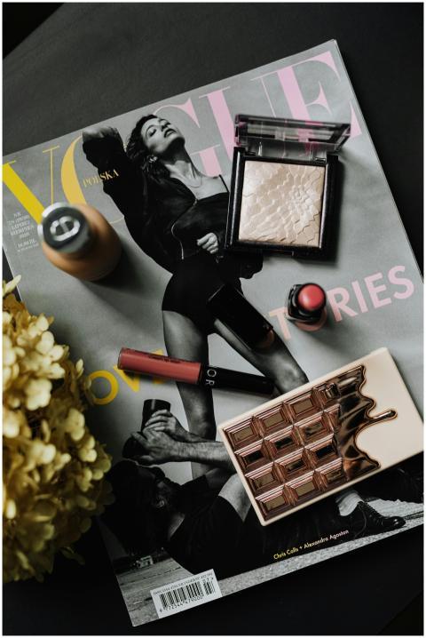 Stylish flat lay of makeup essentials on a Vogue m