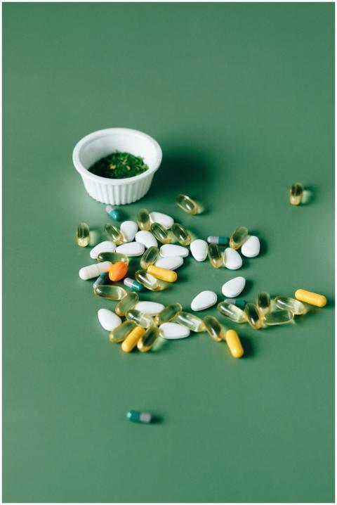 Assorted pills and herbal remedies displayed on gr