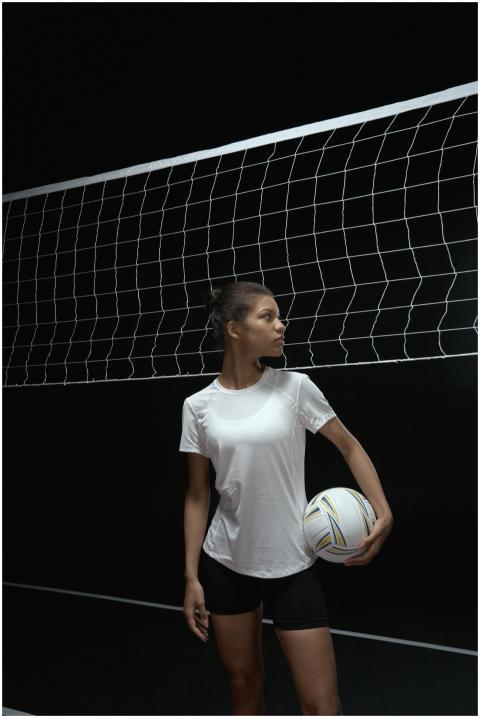 Confident female volleyball player holding a ball