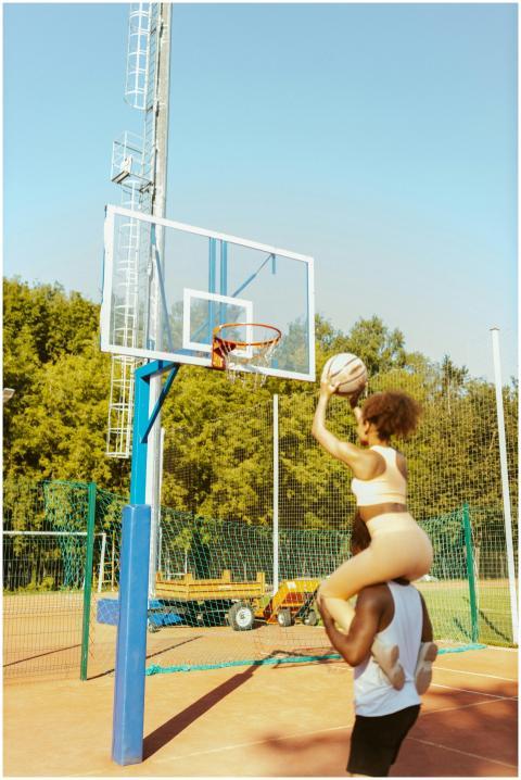 Playful couple playing basketball outdoors, with a