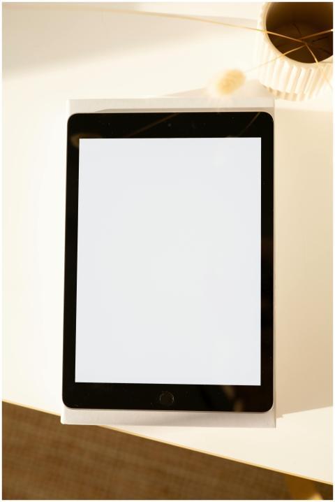 Top-down view of a blank screen tablet on a sunlit