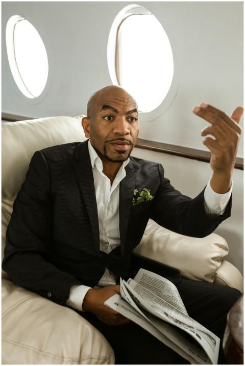 Businessman in a suit reading a newspaper while fl