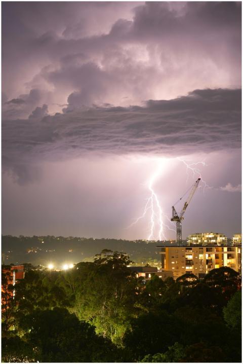 Nighttime lightning strike over a city skyline, hi