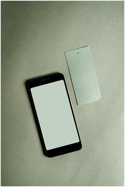 A smartphone with a blank screen alongside a tag o