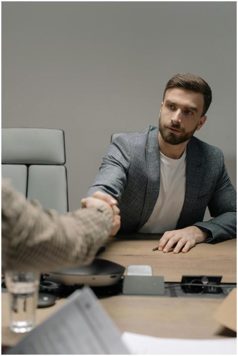 Two businessmen in a modern office shaking hands a