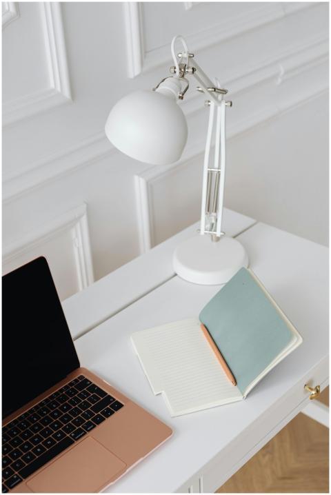 Elegant minimalist desk setup with a laptop, lamp,