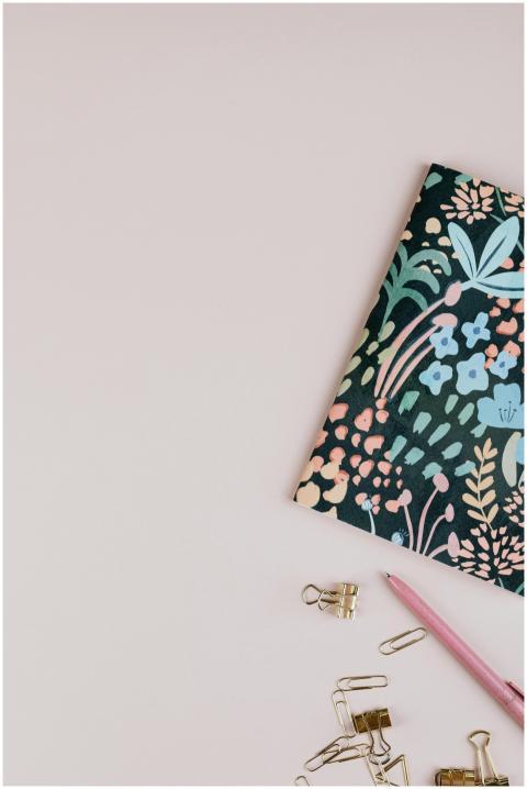 A top view of a floral notebook and stationery on