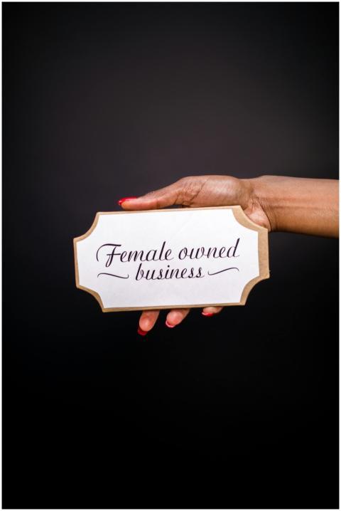 Hand holding a sign with 'Female owned business' o