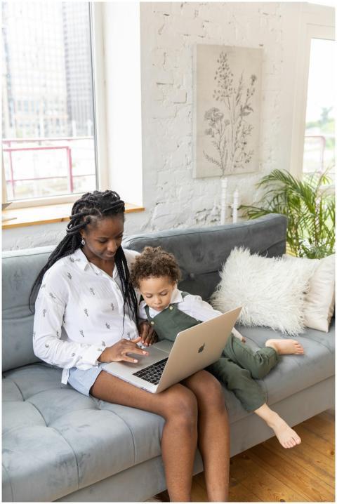 A mother and child comfortably sitting on a couch,