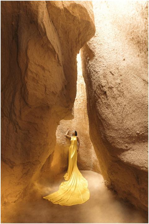 A woman in a striking yellow dress poses confident