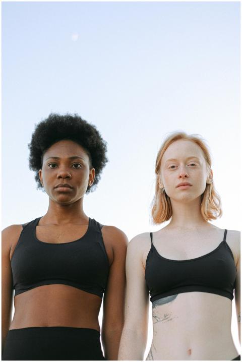 Two diverse women standing confidently in sports b