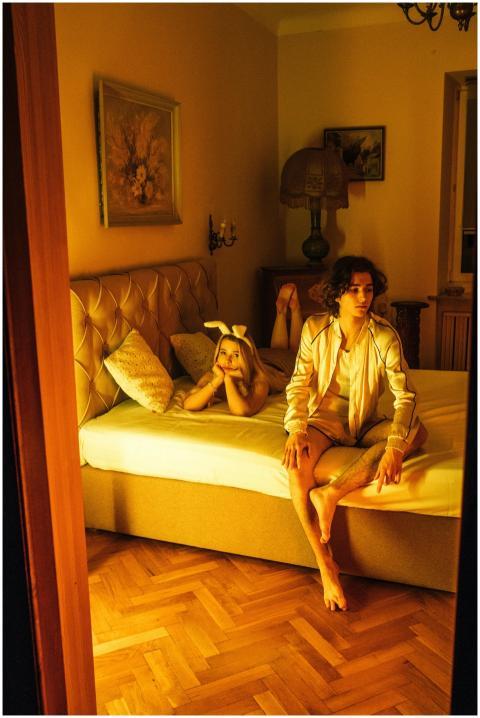 A young couple in a warmly lit bedroom, capturing