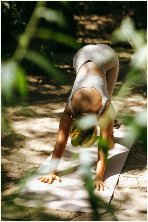 A woman doing yoga in a serene outdoor forest sett