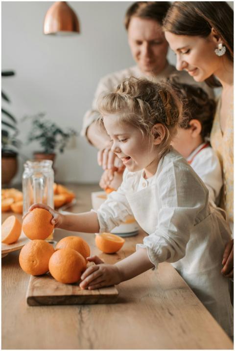 Joyful family with children making fresh orange ju